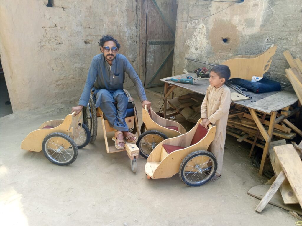 Man and boy with custom made wooden wheelchairs for kids.